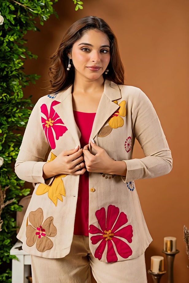 Close-up detail of the vibrant, multi-tone artisan floral embroidery on the premium breathable beige cotton-linen fabric.