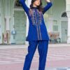 Royal-Blue-Floral-Embroidered-Flex-Cotton-Co-ord-Set-front Royal Blue Floral Embroidered Flex-Cotton Co-ord Set - A woman wearing a royal blue floral embroidered flex-cotton co-ord set with a sharp collar shirt and tapered trousers.
