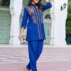 Royal-Blue-Floral-Embroidered-Flex-Cotton-Co-ord-Set-styled-left-profile Left side profile of a woman in a royal blue embroidered tunic shirt showing the floral detailing on the sleeve and side-slit hem.