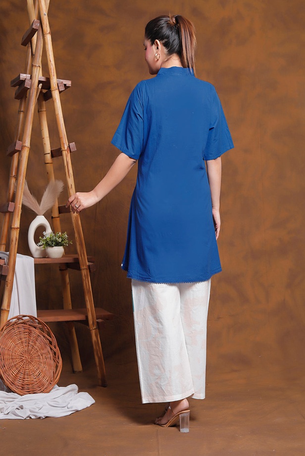 Back view of women's asymmetric tunic and abstract printed trousers showing a flowing hemline.