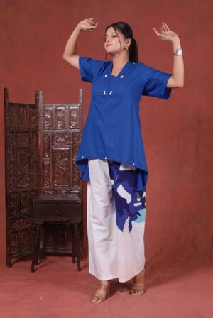 Royal Blue High-Low Tunic & Wide-Leg Printed Pant Co-Ord Set - This front-view of a woman shows exactly how the outfit falls naturally. The bright royal blue top features a clean V-neck with cute white button details and breezy half-sleeves.