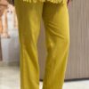 Close-up of the fabric, tailoring, and hemline on the trouser leg of the mustard yellow Artisan 2-piece co-ord set.
