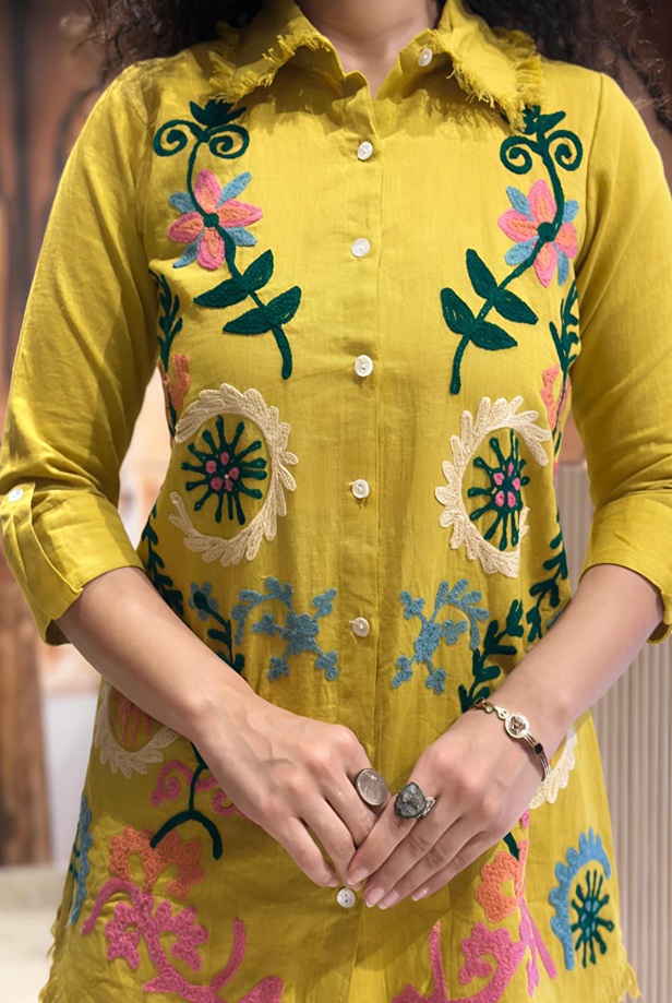 Extreme close-up of the intricate embroidery pattern on the Mustard Yellow fabric of the Artisan 2-piece co-ord set.