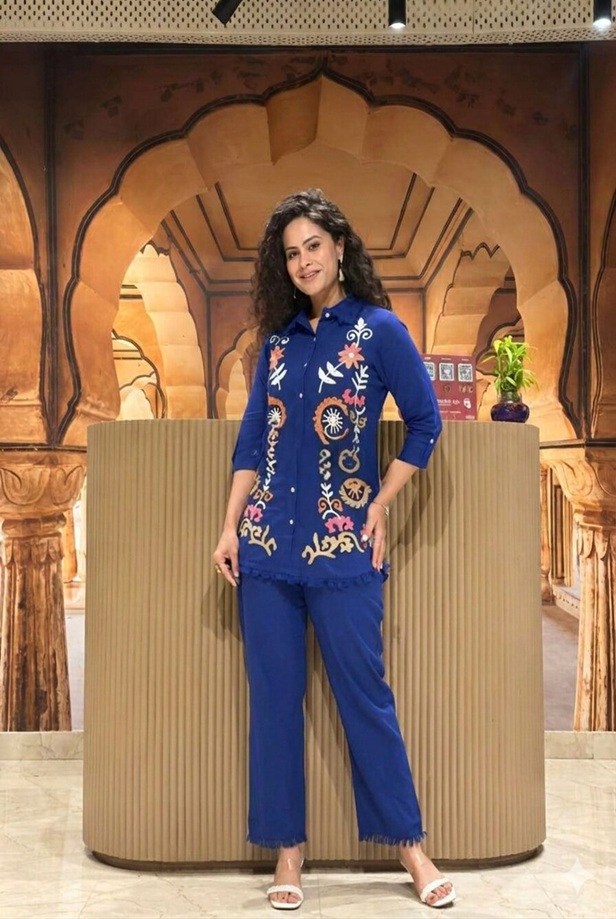Cobalt blue boho floral embroidered linen co-ord set - Front view of a woman modeling the relaxed button-down top and matching trousers by Fashion Bites.
