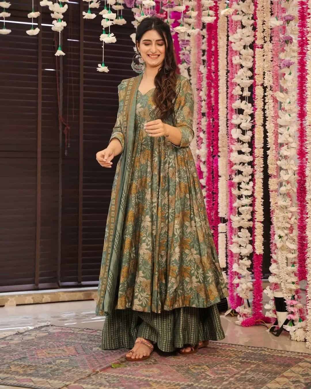 A model styled with oxidized silver jhumkas and flat sandals wearing the olive garden floral Anarkali set.
