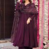 A woman wearing a deep wine-colored flared Anarkali kurta with silver neckline embroidery and a matching Bandhani print dupatta.
