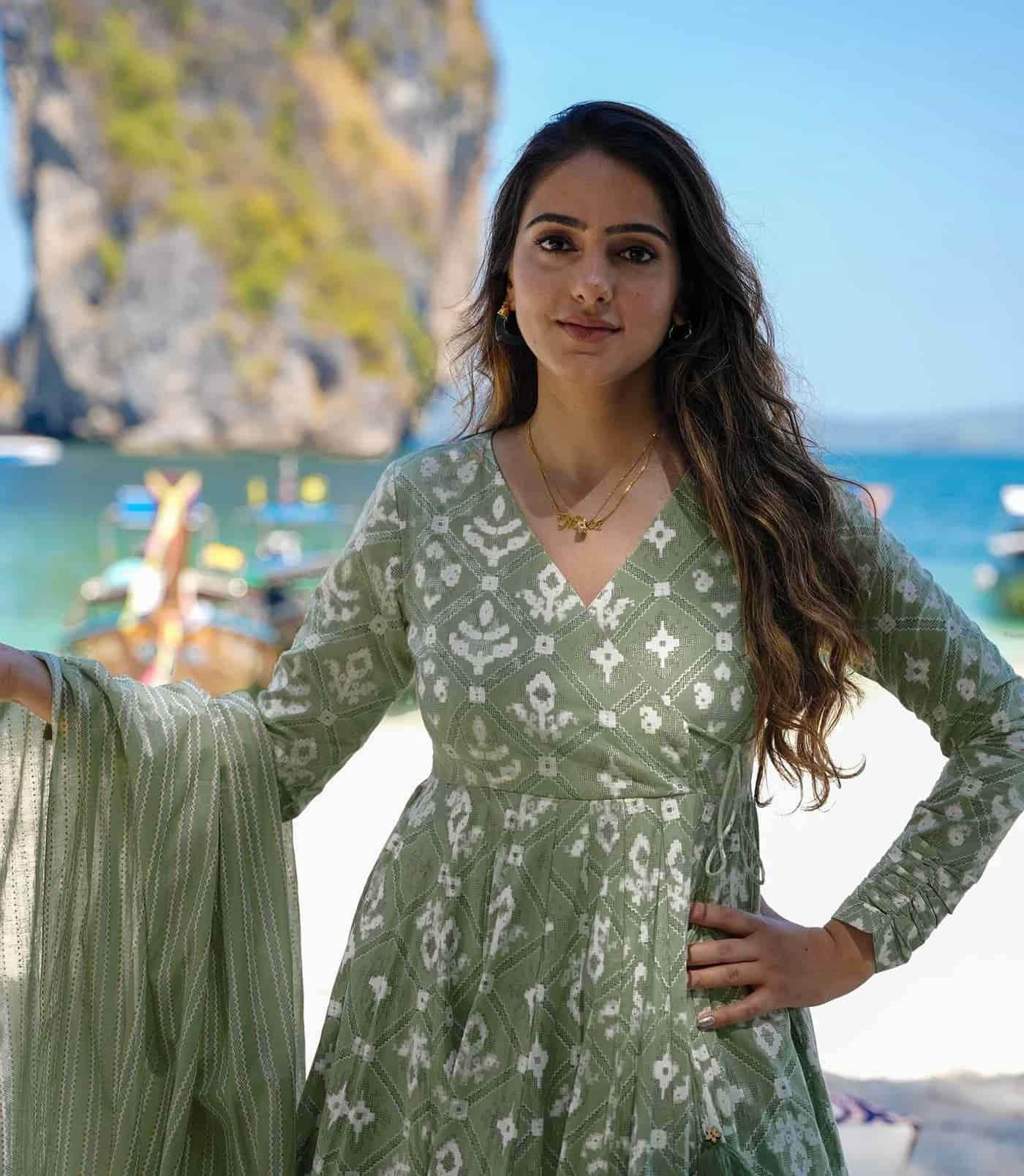 Macro shot of white geometric and floral block prints on a sage green fabric base.