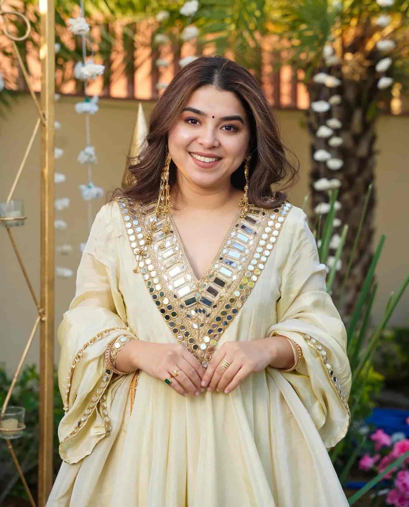 Macro shot of reflective mirrors and gold threadwork on an ivory organza peplum hem.