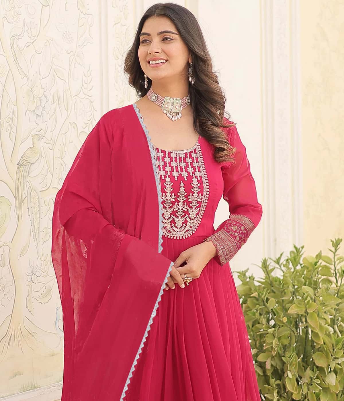 Close-up detail of silver floral threadwork and sparkling sequins on scarlet red fabric.