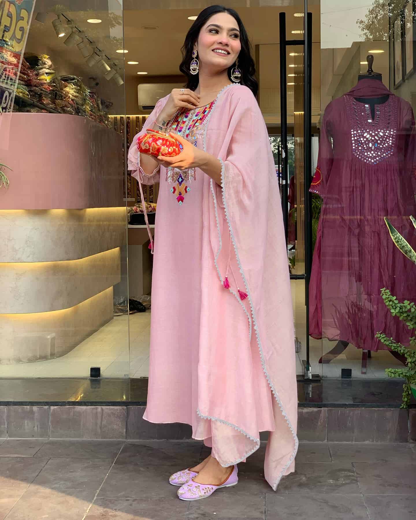 Side shot of a pink bohemian kaftan highlighting the loose-fit sleeves and delicate tassel-tie accents.