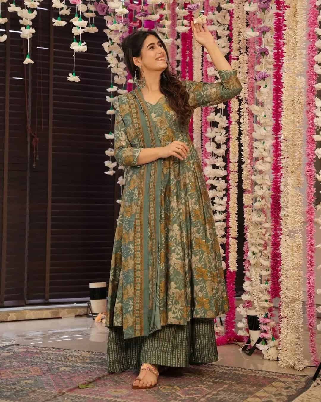 Full-length original product shot of an olive green floral Anarkali with matching striped palazzo pants and a floral dupatta.
