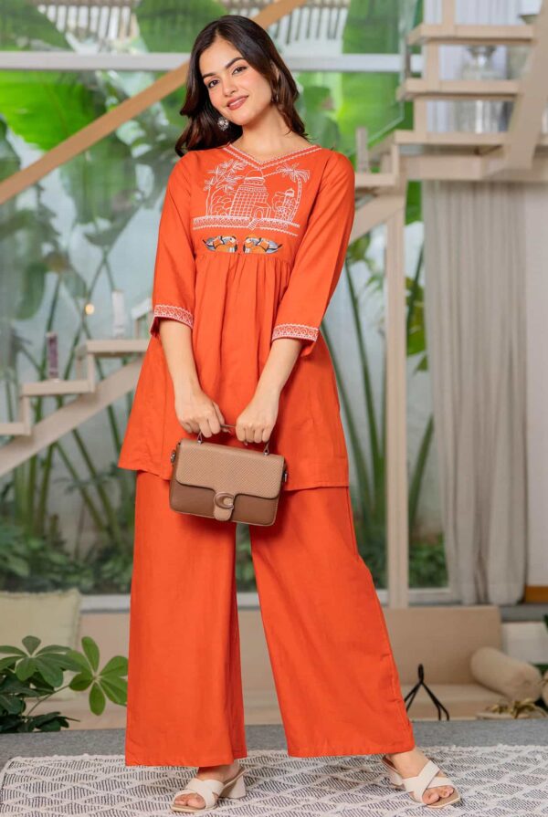 A model styled with traditional gold jhumkas and a bindi wearing the Burnt Orange embroidered Anarkali set.