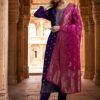 A woman wearing a premium amethyst purple silk kurta with gold zari neck detailing and a contrast magenta dupatta.