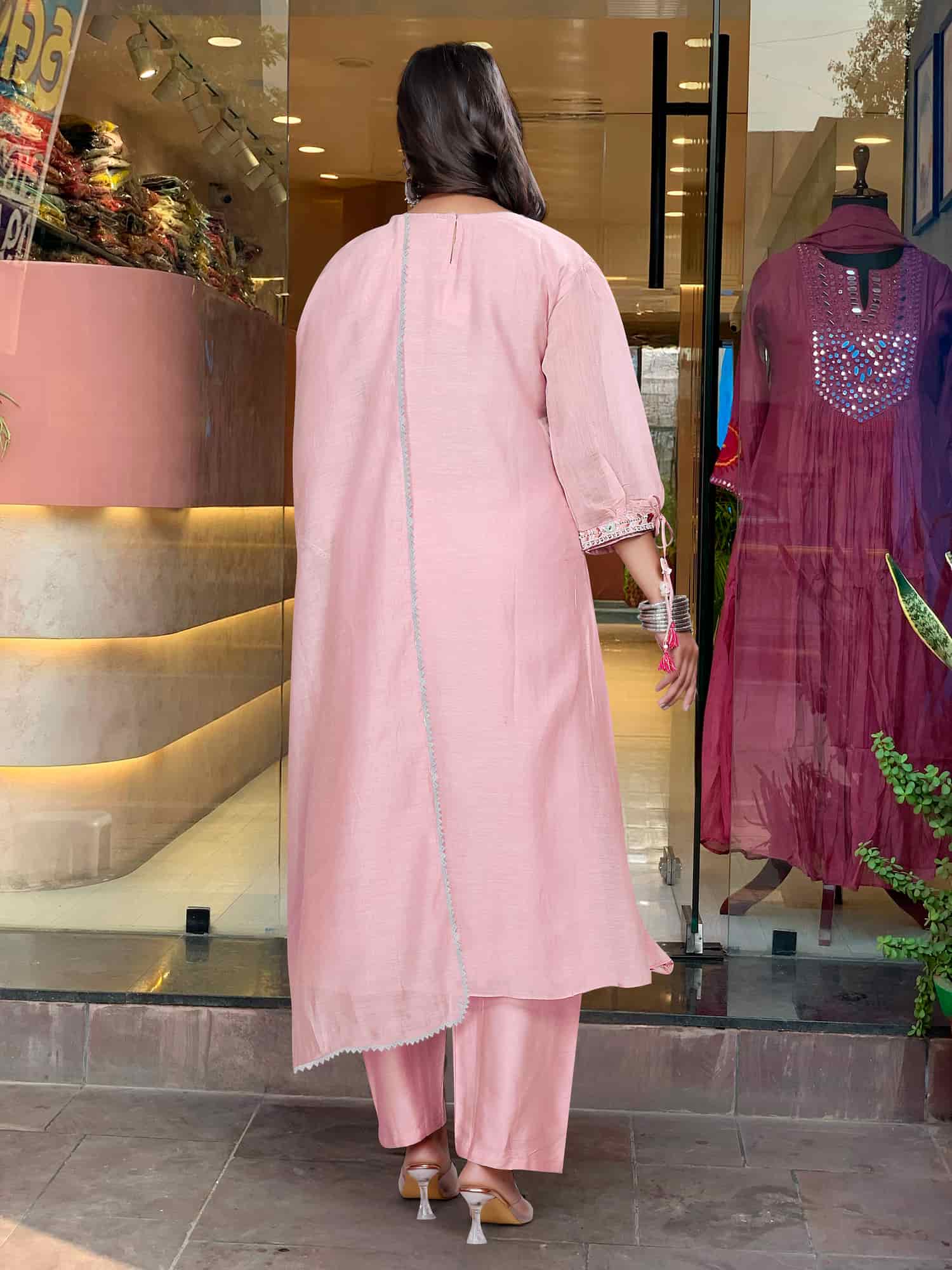Rear view of a blush pink silk-blend kaftan showing a clean finish and the fluid, airy drape of the fabric.