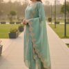 Side shot of an aqua silk suit highlighting the fluid drape of the trousers and scalloped organza dupatta.