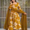 A woman wearing a mustard yellow floor-length Anarkali with large white floral prints and a matching dupatta.