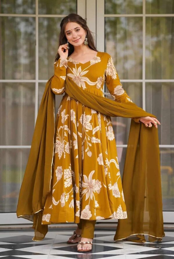 A woman wearing a mustard yellow floor-length Anarkali with large white floral prints and a matching dupatta.