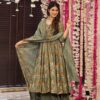 A woman posing in a flared olive green Anarkali featuring earth-toned floral prints and a matching dupatta with striped palazzo pants.