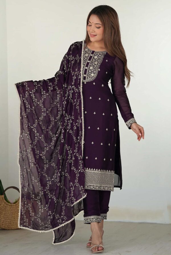 A woman wearing a deep plum purple straight-fit kurta with silver zari embroidery and a matching dupatta.