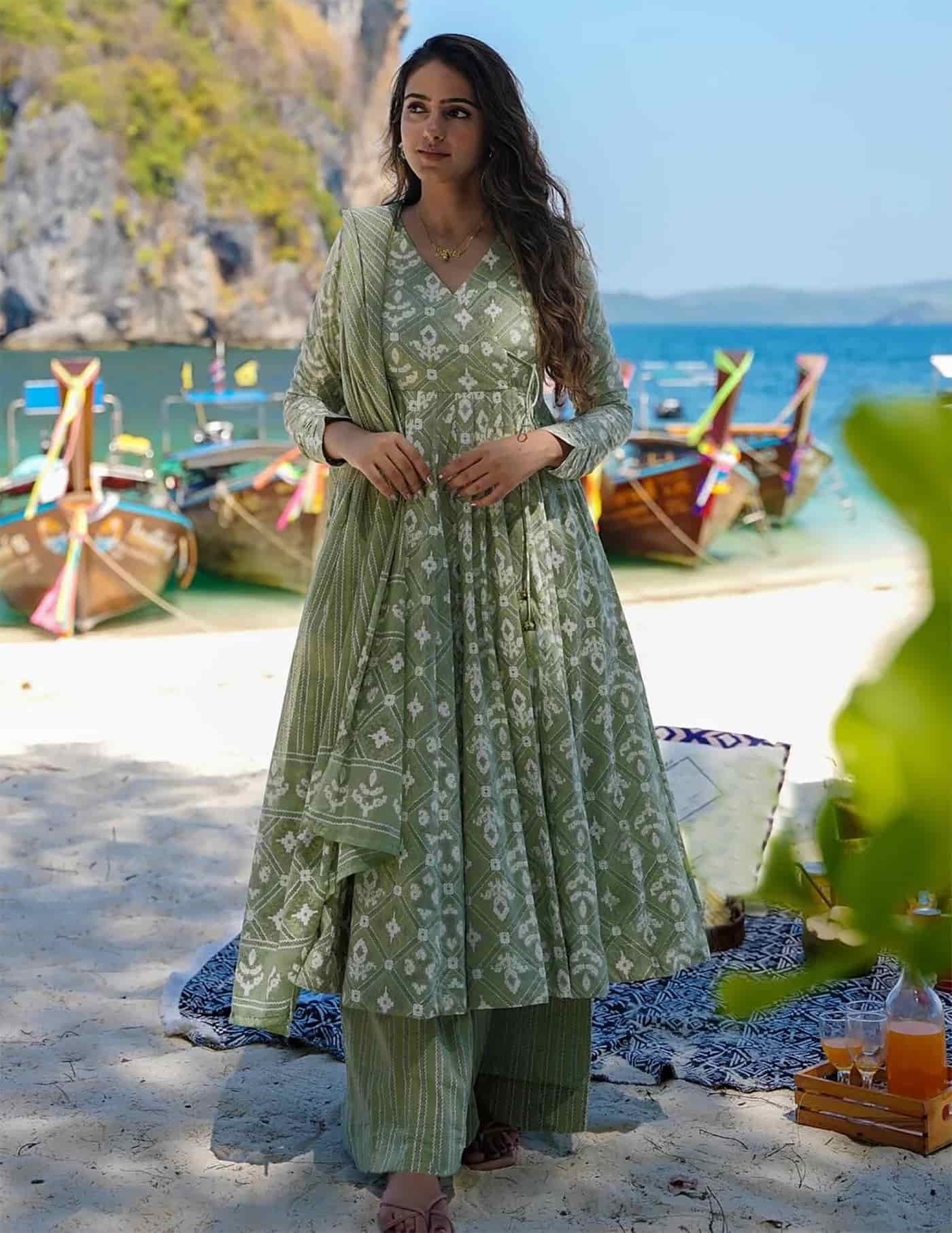 A woman wearing a sage green block-printed Angrakha kurta with a flared hem and matching palazzo pants.