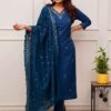 A woman in a deep sapphire blue straight-fit silk kurta featuring a silver embroidered V-neckline and matching pants.