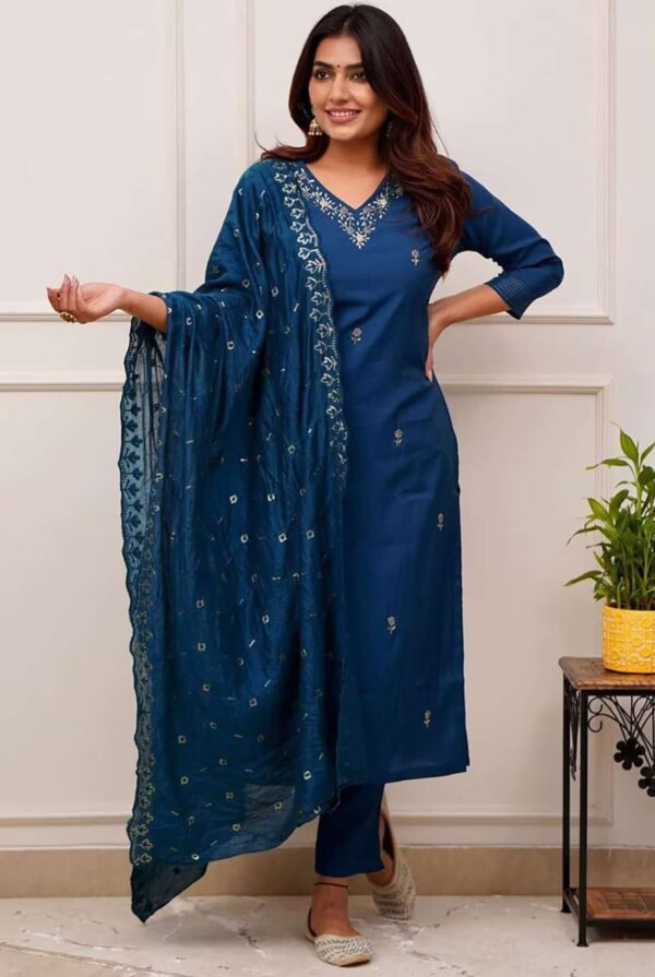 A woman in a deep sapphire blue straight-fit silk kurta featuring a silver embroidered V-neckline and matching pants.