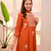 Side profile of an orange embroidered silk kurta highlighting the three-quarter sleeves and fluid drape.