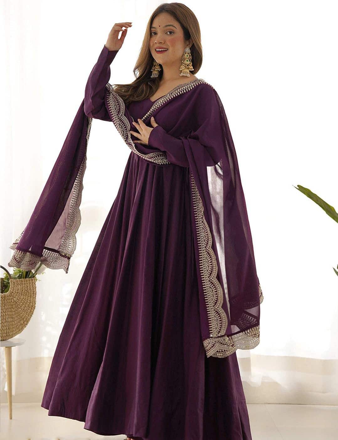 Front view of a floor-length deep wine purple Anarkali suit with long sleeves and a matching sheer dupatta.